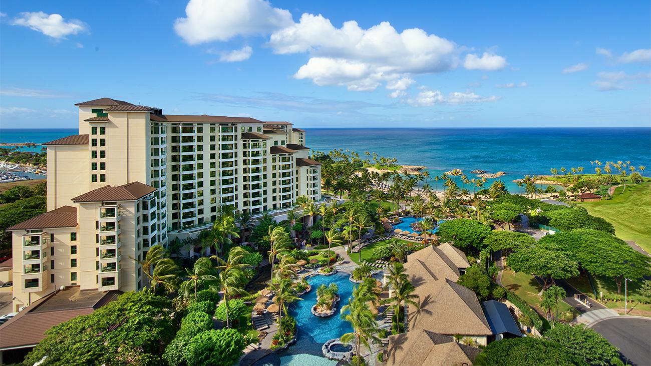 Aerial of exterior of Marriott's Ko Olina Beach Club resort timeshare showing pool complex and ocean at a distance